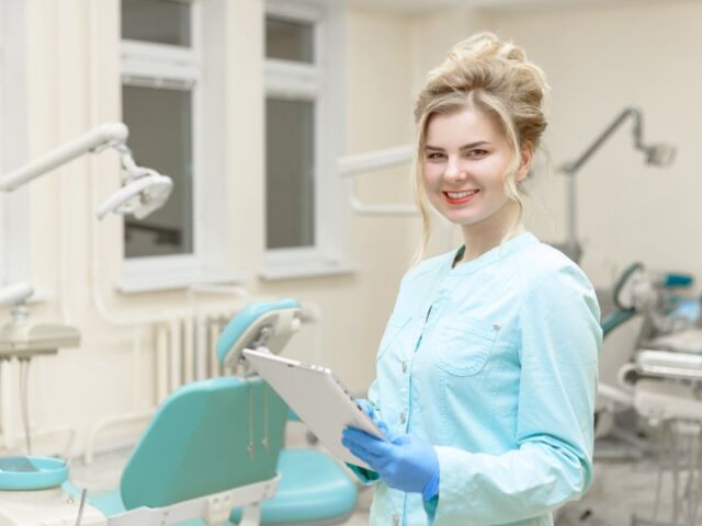 A healthcare provider in a dental office discusses the preparatory steps for dental implants, including medical evaluations and oral hygiene practices